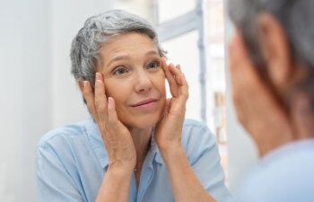 old woman looks in the mirror