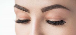 Close-up of closed woman's eyes and eyebrows.